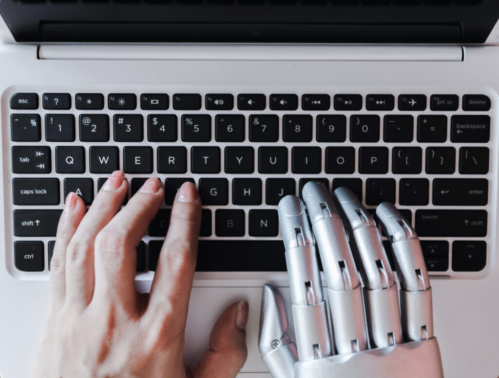 Hands on keyword. One human hand and other robotic hand to represent artificial intelligence in Practice